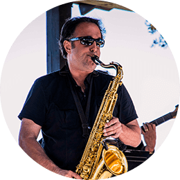 An entertainer on the outdoor festival stage playing saxophone.