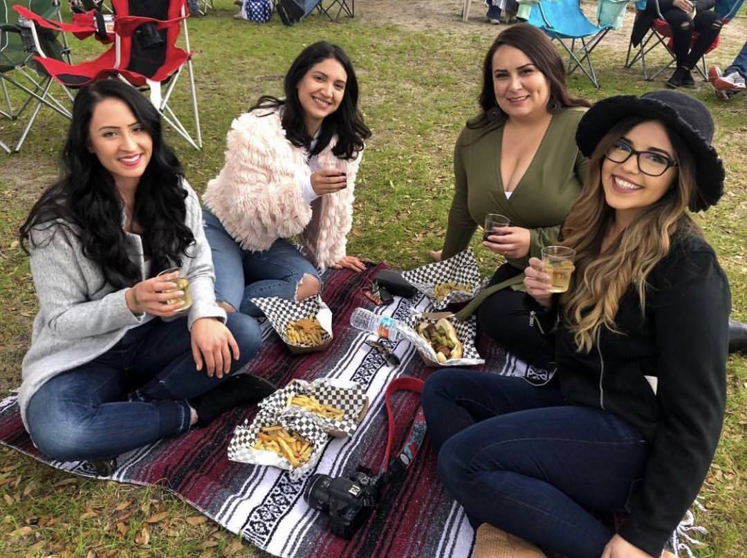 Young women enjoying a glass of wine and food outside