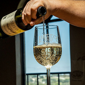 Bottle of Southern Whtie wine being poured into a glass on a table top.